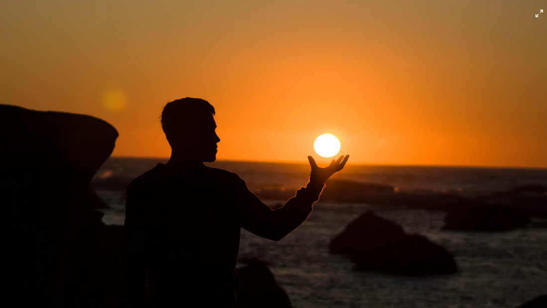 Silhuet ved solnedgang som symbol på NAD+, cellulær energi og biologiske processer.