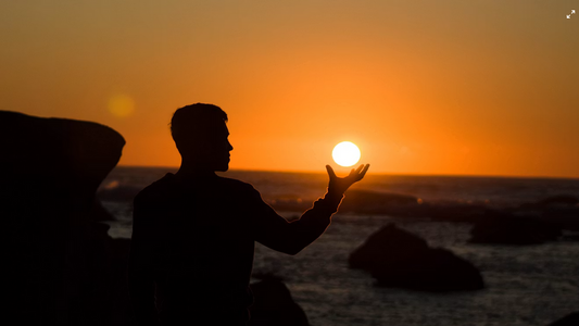 Silhuet ved solnedgang som symbol på NAD+, cellulær energi og biologiske processer.